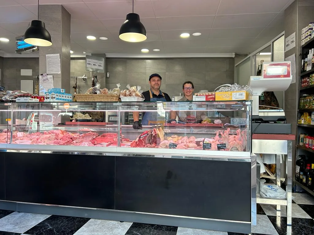 Esteban and Mónica serving behind the counter